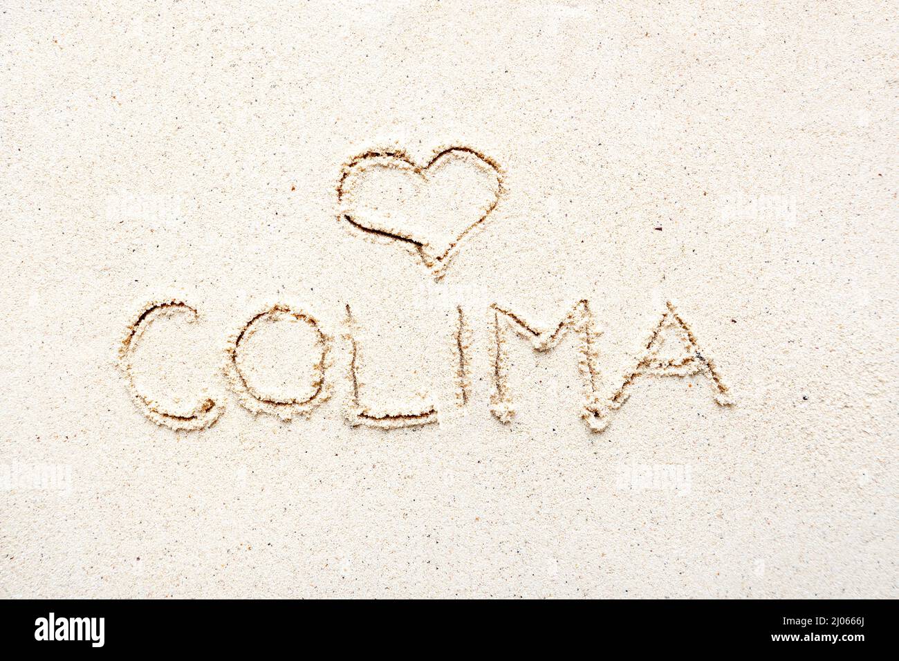 Scrivere a mano le parole 'Colima' sulla sabbia della spiaggia Foto Stock