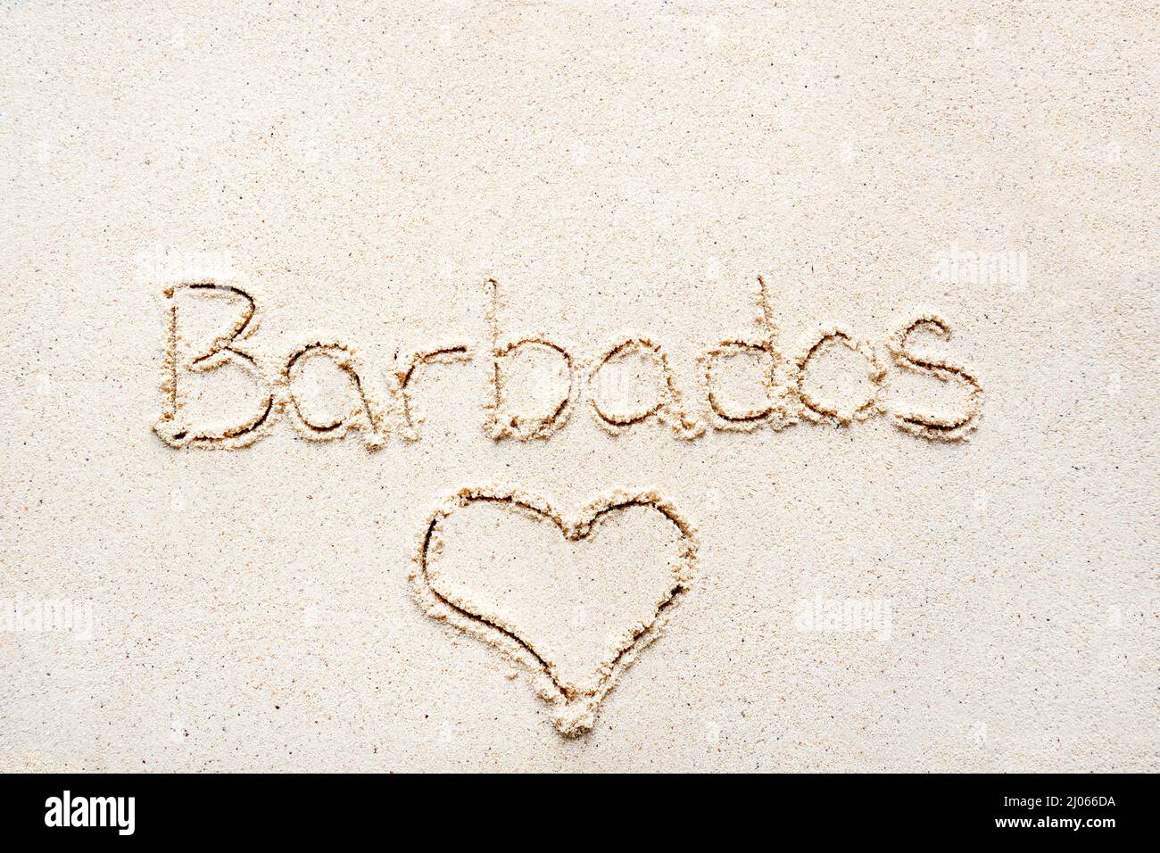 Scrivere a mano le parole 'Barbados' sulla sabbia della spiaggia Foto Stock