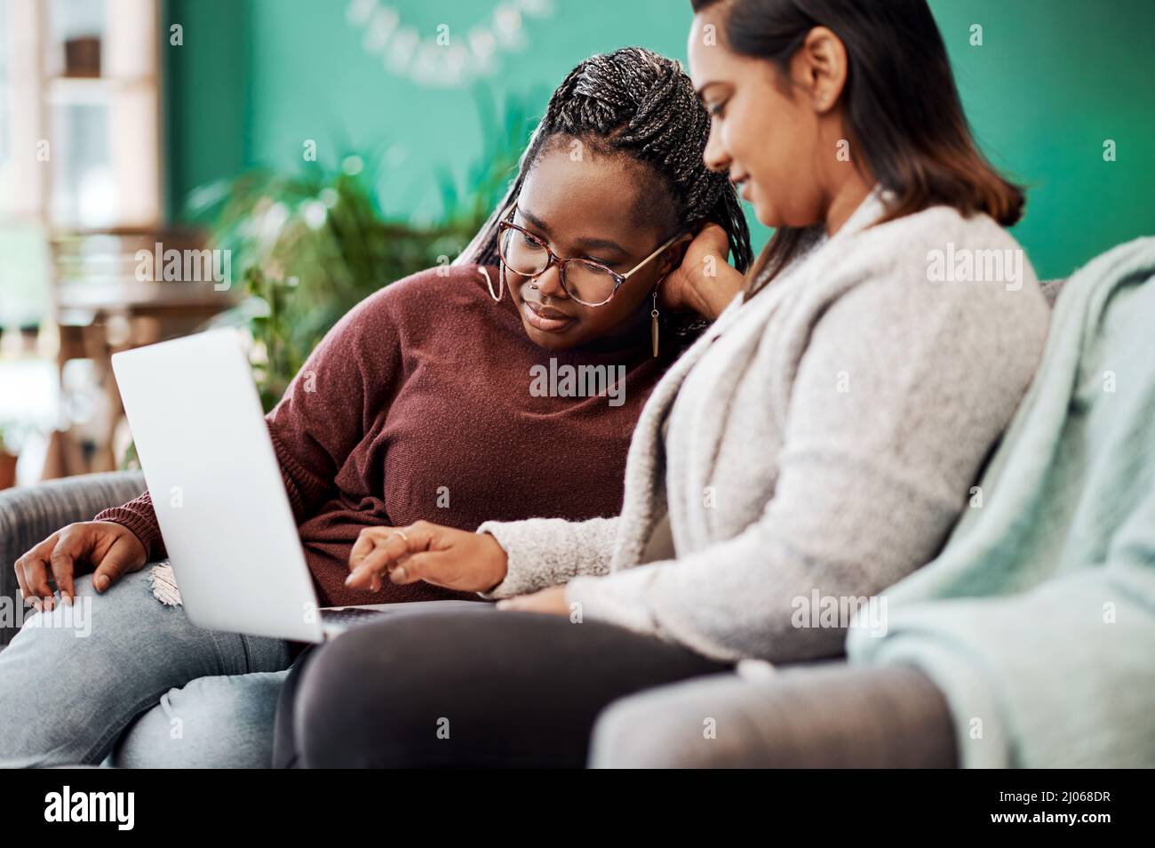 I migliori amici conoscono i migliori blog di moda. Scatto di due giovani donne utilizzando un computer portatile sul divano a casa. Foto Stock