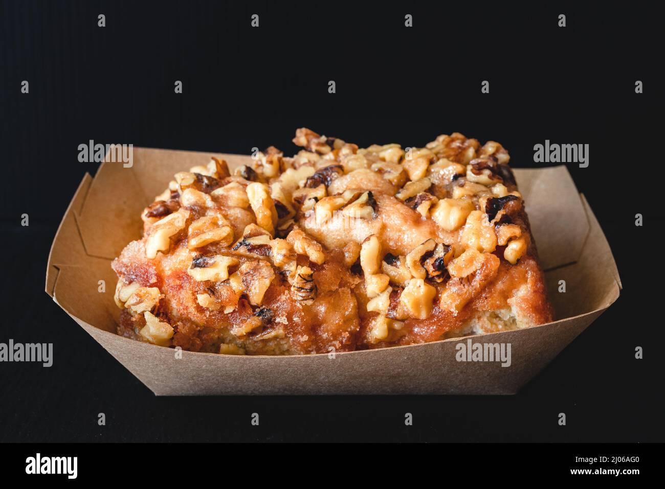 Rotolo di cannella smerigliato in noce da vicino su sfondo nero Foto Stock