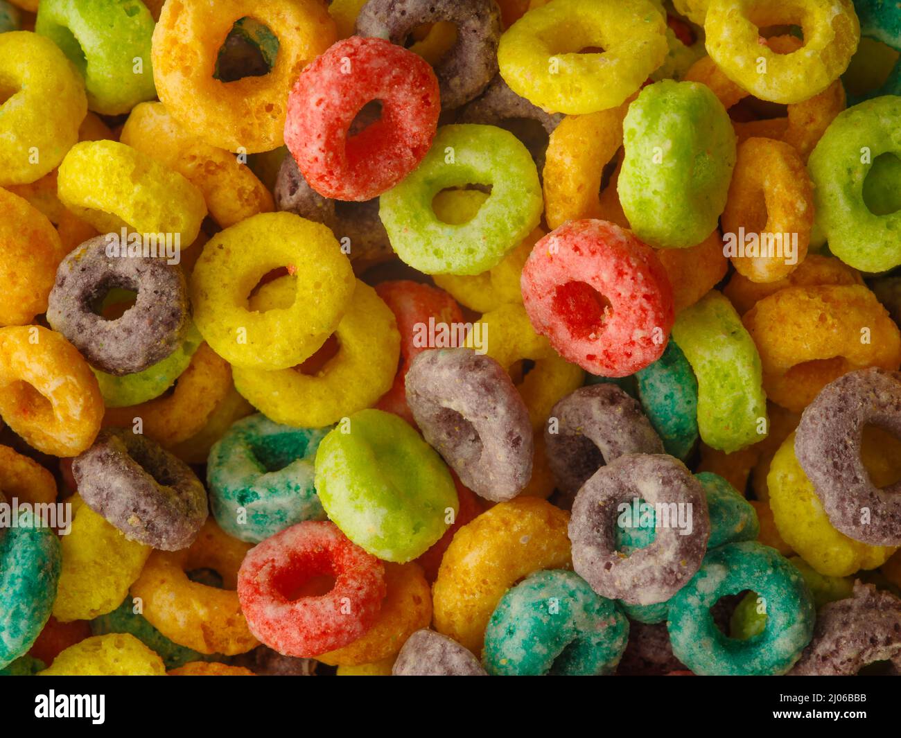 Anelli colorati croccanti di frutta a grano intero. Grande gruppo di oggetti. Scatto macro. Colazione veloce cereali, piatti vegetariani e salutari per bambini. Vita Foto Stock