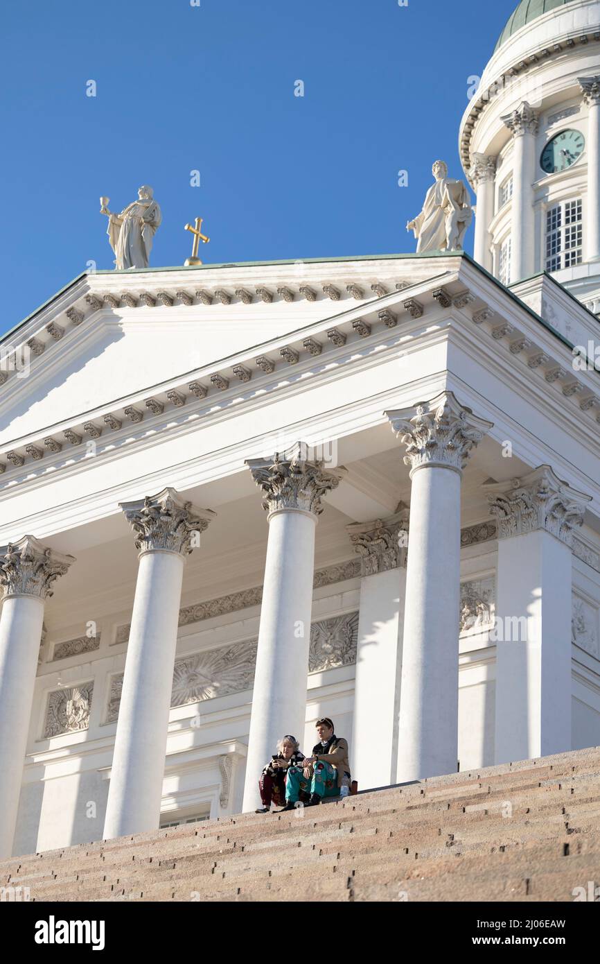 Helsinki, Finlandia. 16th Mar 2022. La gente si crogiola al sole alle scale della Cattedrale di Helsinki, in Finlandia, 16 marzo 2022. Credit: Matti Matikainen/Xinhua/Alamy Live News Foto Stock