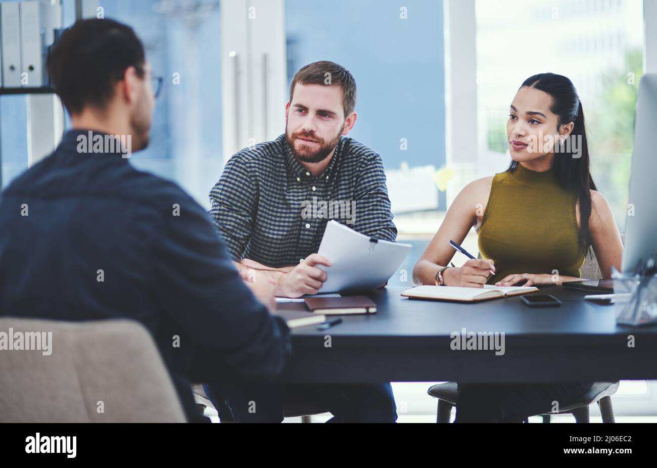 Condividere pensieri e idee. Foto di un gruppo di giovani designer che hanno una discussione in un ufficio. Foto Stock