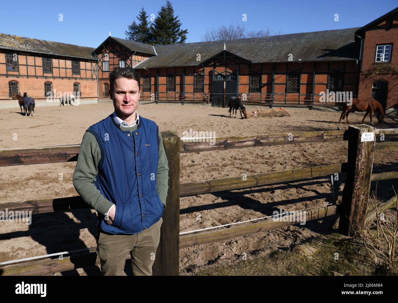 Panker, Germania. 11th Mar 2022. Achaz von Wintzingerode, amministratore della Hessian House Foundation di Gut Panker, si trova di fronte a una scuderia di cavalli della tenuta. Per mantenere le grandi proprietà dello Schleswig-Holstein, sono necessarie imprese solide. Dove l'agricoltura e la silvicoltura non sono sufficienti, i signori e le Signore del maniero contano sui mercati e sugli eventi di Natale. (A dpa-Korr 'Vacanze nella fattoria davvero grande: Turismo immobiliare nel nord') Credit: Christian Charisius/dpa/Alamy Live News Foto Stock