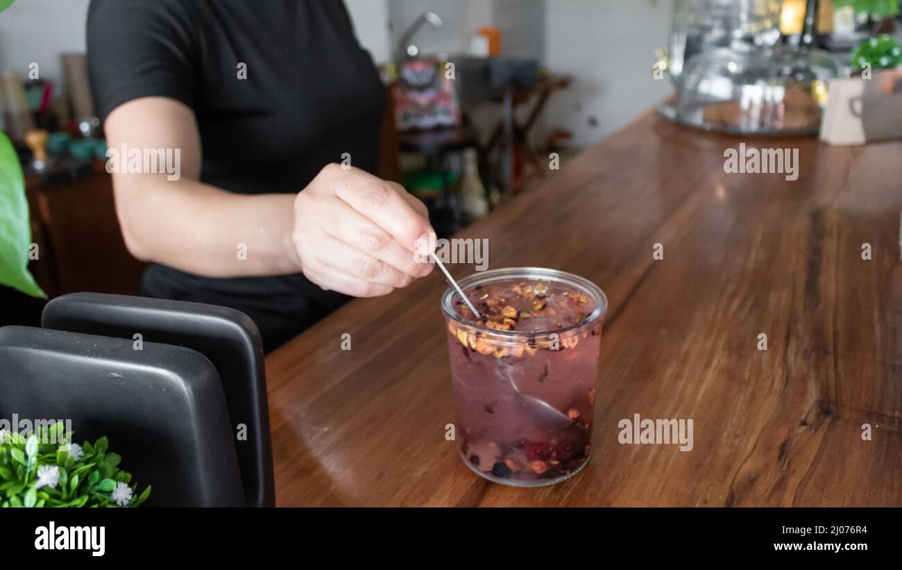 giovane adulto ispanico che indossa una maschera dietro un registratore di cassa in una caffetteria messicana Foto Stock