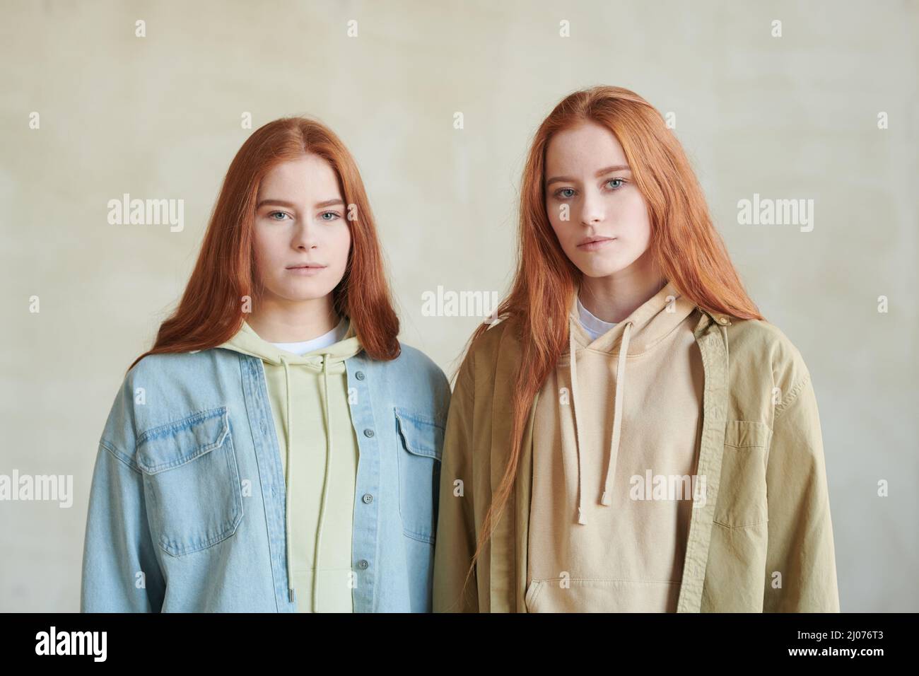 Orizzontale medio ritratto studio di due belle giovani sorelle cacuasiche gemelle in piedi togeter guardando la macchina fotografica Foto Stock