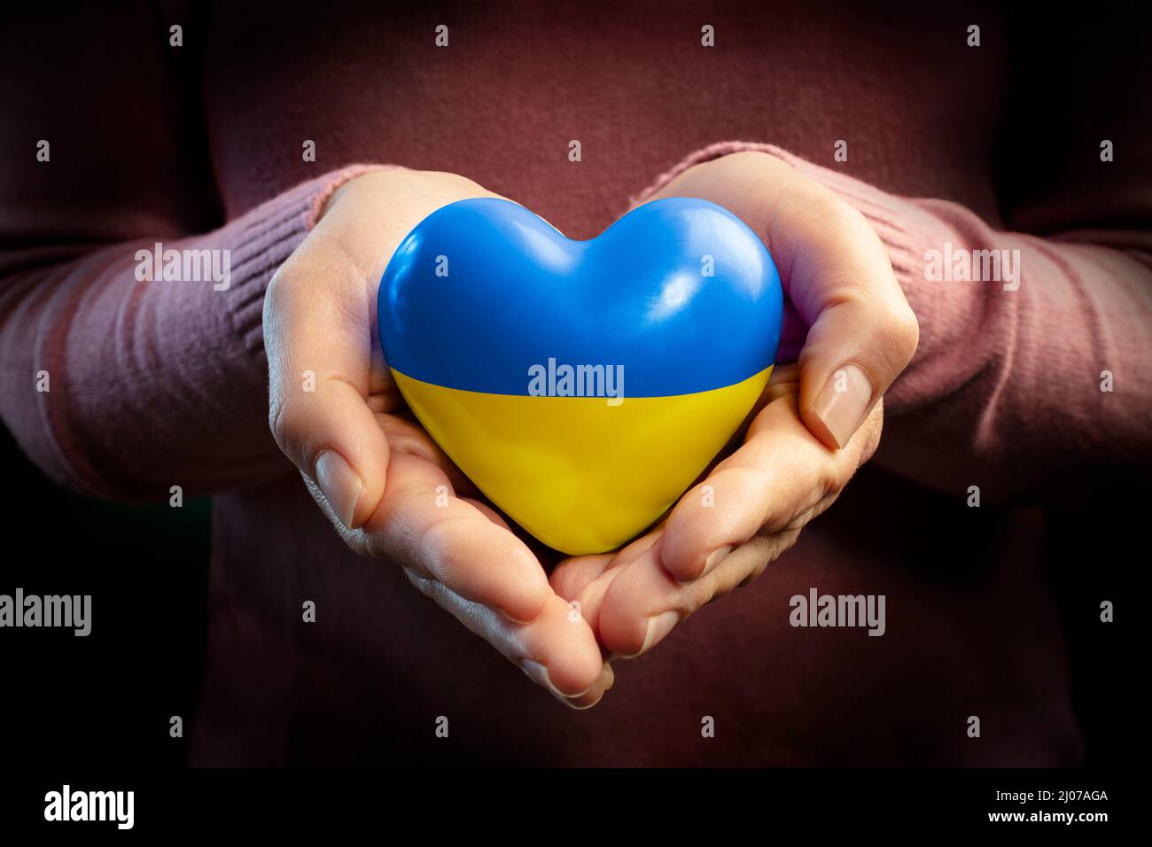 Pregate per l'Ucraina - mani con cuore e bandiera Ucraina - Pace e No War Concept Foto Stock