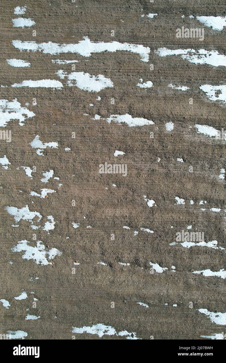 Superficie di terra marrone con macchie di neve bianca sopra la vista del drone superiore Foto Stock