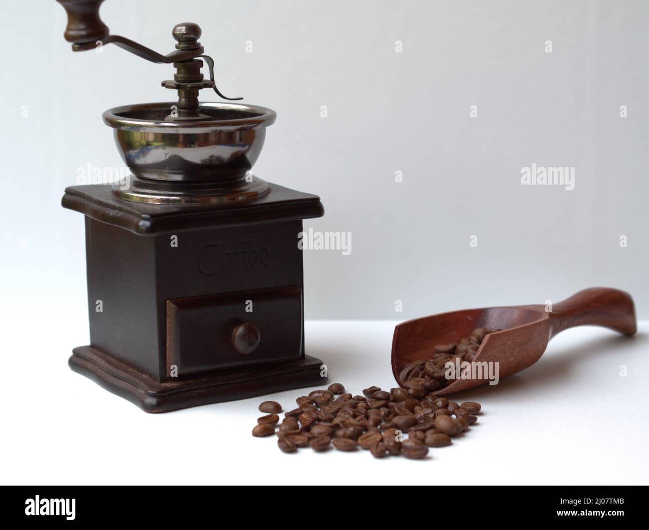 Chicchi di caffè su cucchiaio di legno e macinacaffè d'epoca Biji Kopi dan Penggiling Biji Kopi Kayu Vintage Foto Stock