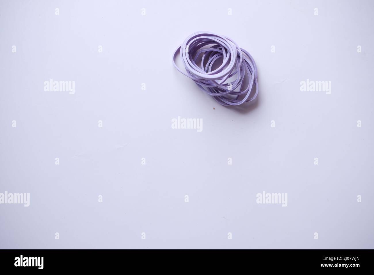 Bande in gomma di colore viola sul tavolo Foto Stock