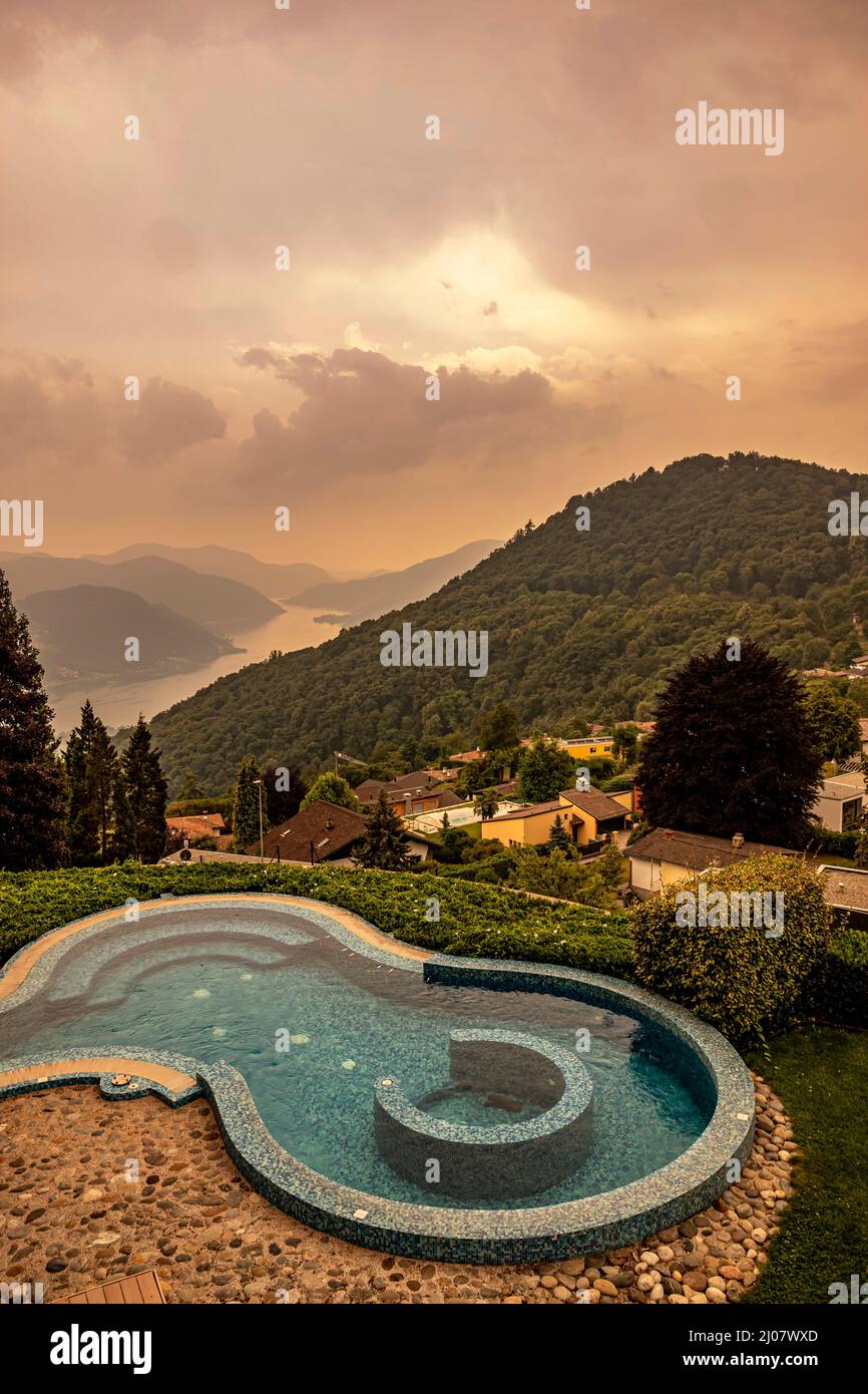 Piscina e vista panoramica sul lago alpino di Lugano e sulla montagna in Ticino, Svizzera. *** Locale Caption *** piscina, piscina, design, moderno, Foto Stock