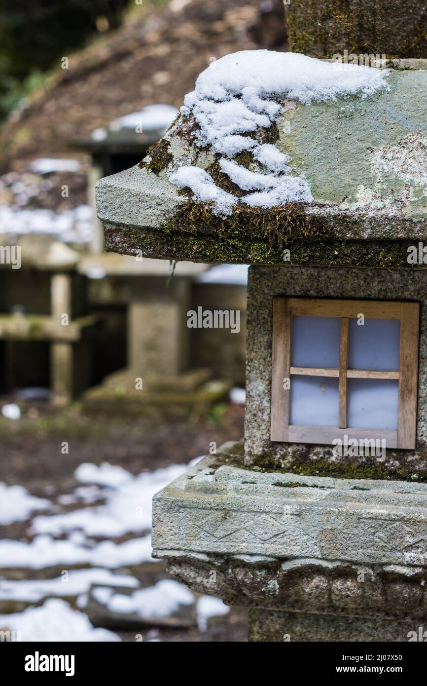 Tradizionale lanterna in pietra giapponese coperta di neve al tempio Kurama-dera di Kyoto in Giappone Foto Stock