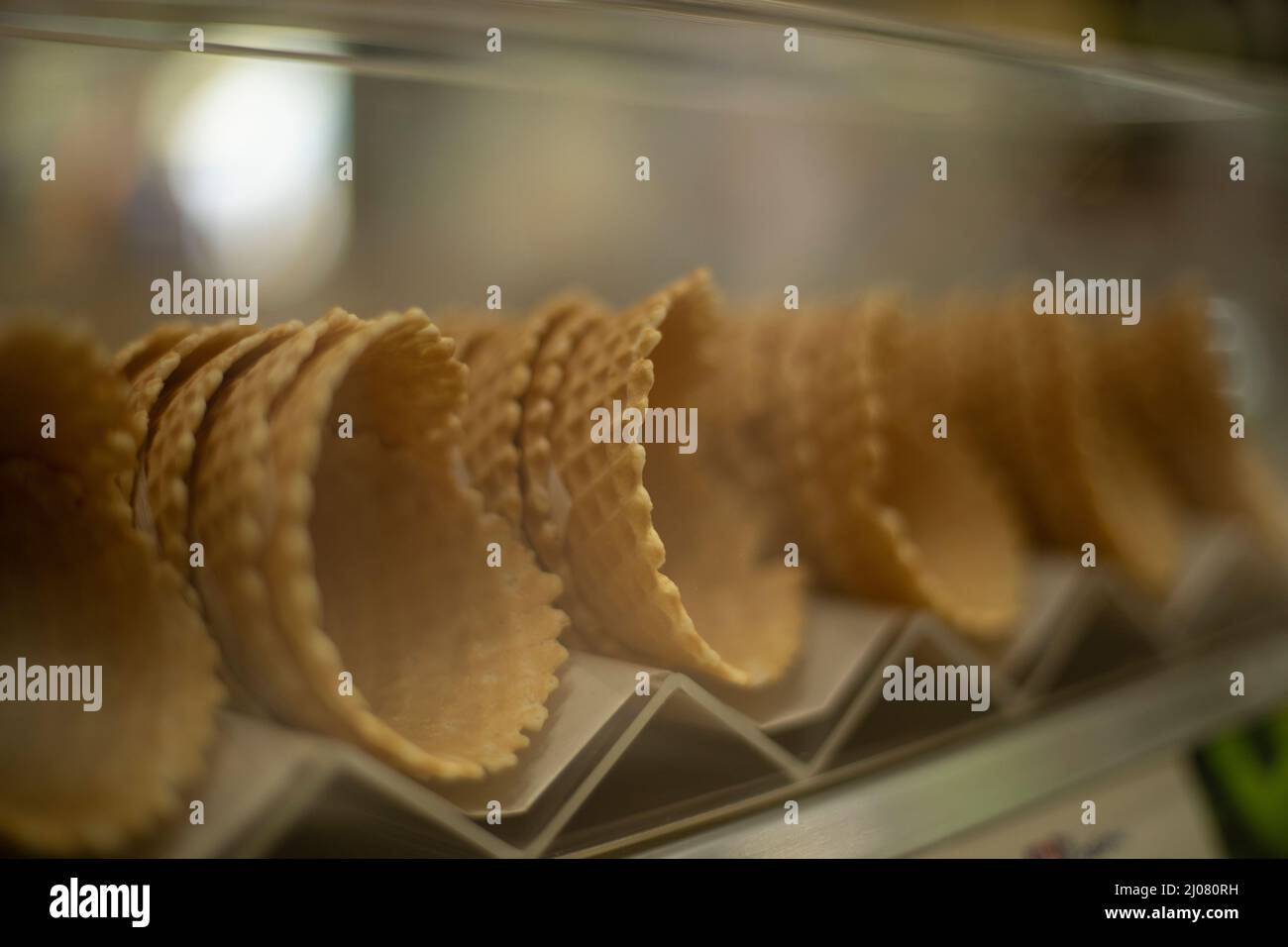 Coni per waffle per gelato. Dolci sulla vetrina del negozio. Cibo delizioso. Waffle appena sfornati. Foto Stock