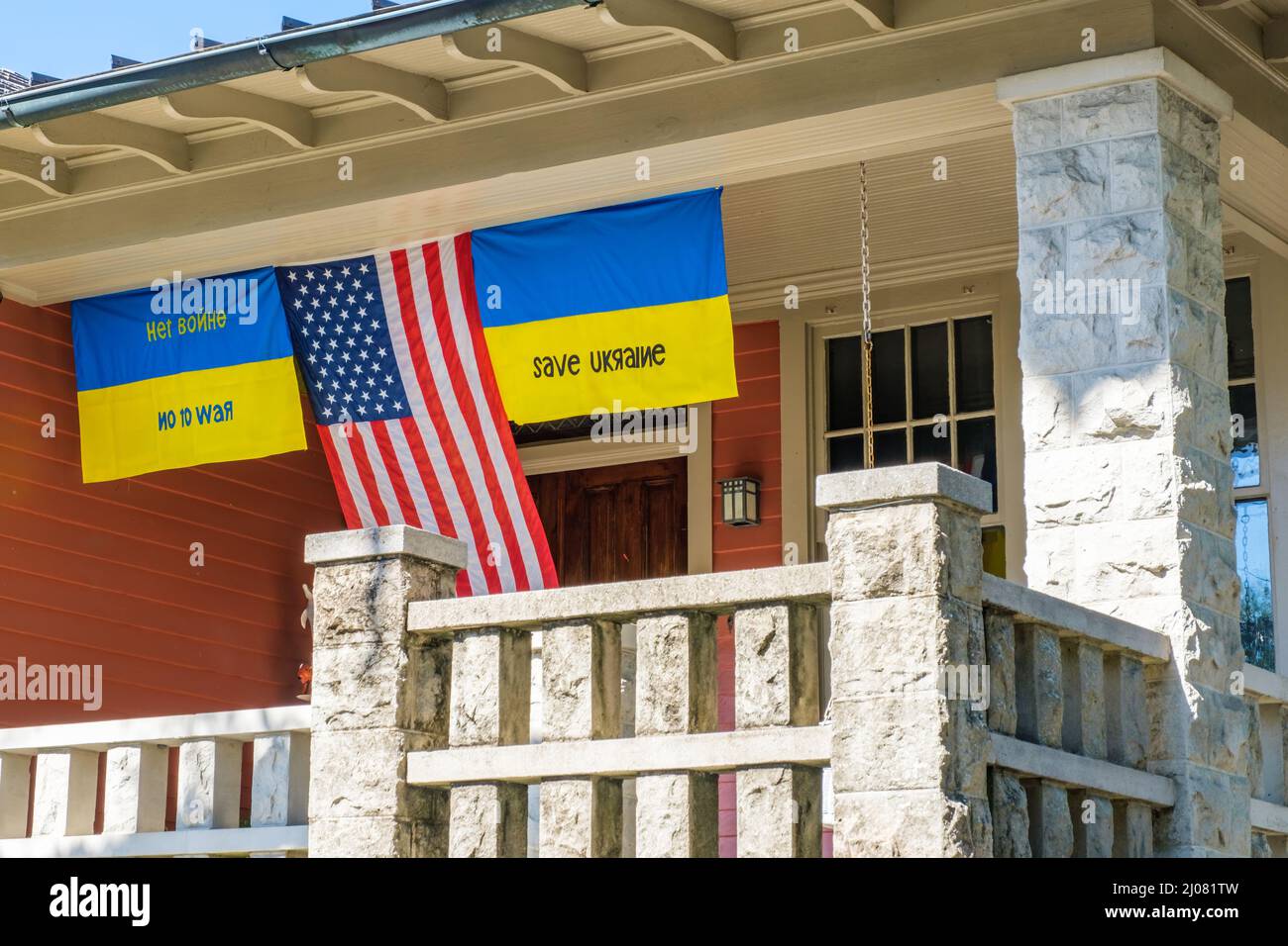 NEW ORLEANS, LA, Stati Uniti d'America - 15 MARZO 2022: Bandiera degli Stati Uniti e bandiere ucraine appese dal portico anteriore della casa a Uptown New Orleans Foto Stock