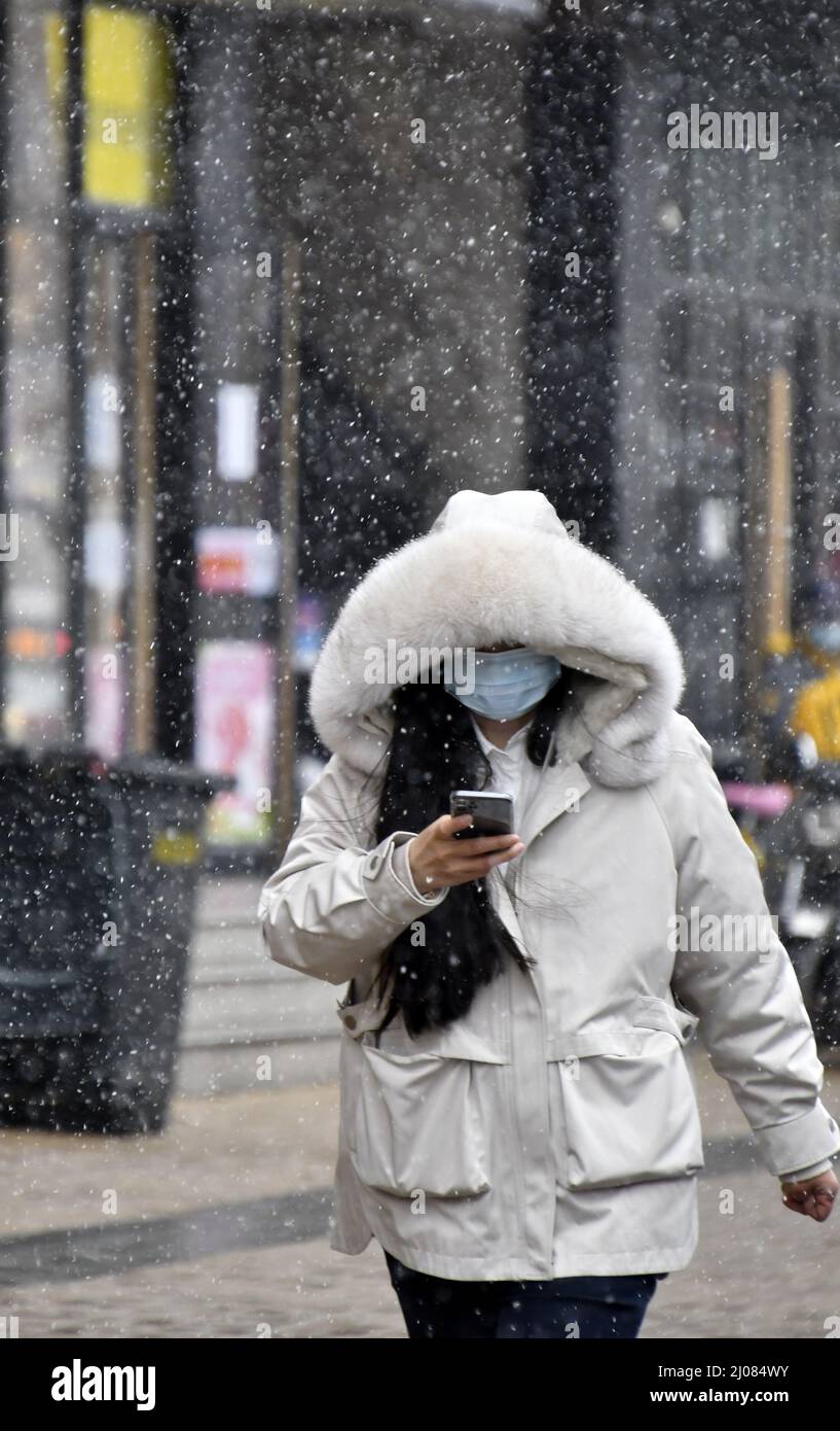 (220317) -- PECHINO, 17 marzo 2022 (Xinhua) -- Un cittadino cammina nella neve a Pechino, capitale della Cina, 17 marzo 2022. Giovedì le autorità meteorologiche cinesi hanno emesso un allarme blu per la neve alta nella parte settentrionale del paese. (Xinhua/li Xin) Foto Stock