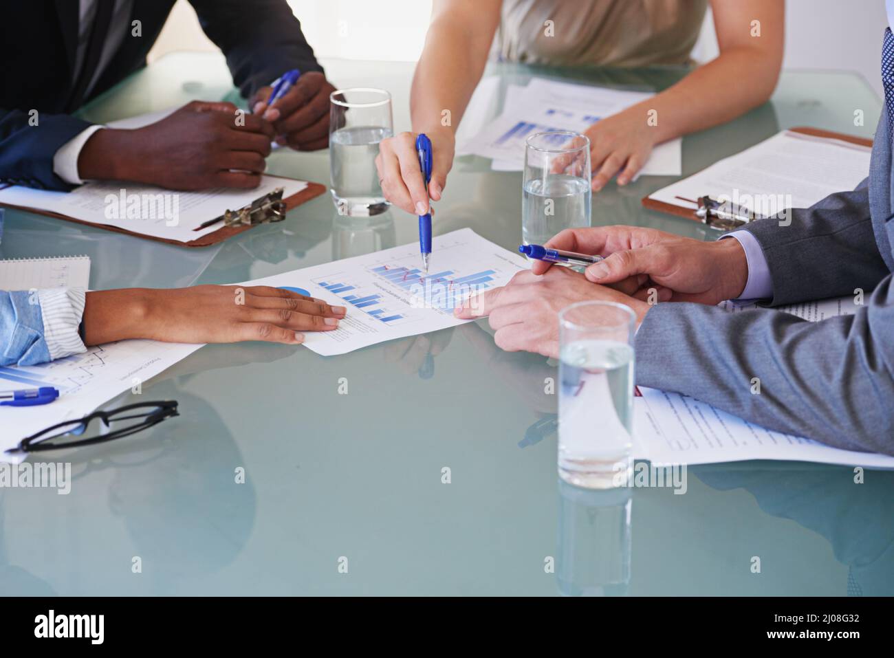 Dai un'occhiata ai numeri. Ripresa ritagliata di un gruppo di uomini d'affari che discutono documenti finanziari in una riunione. Foto Stock