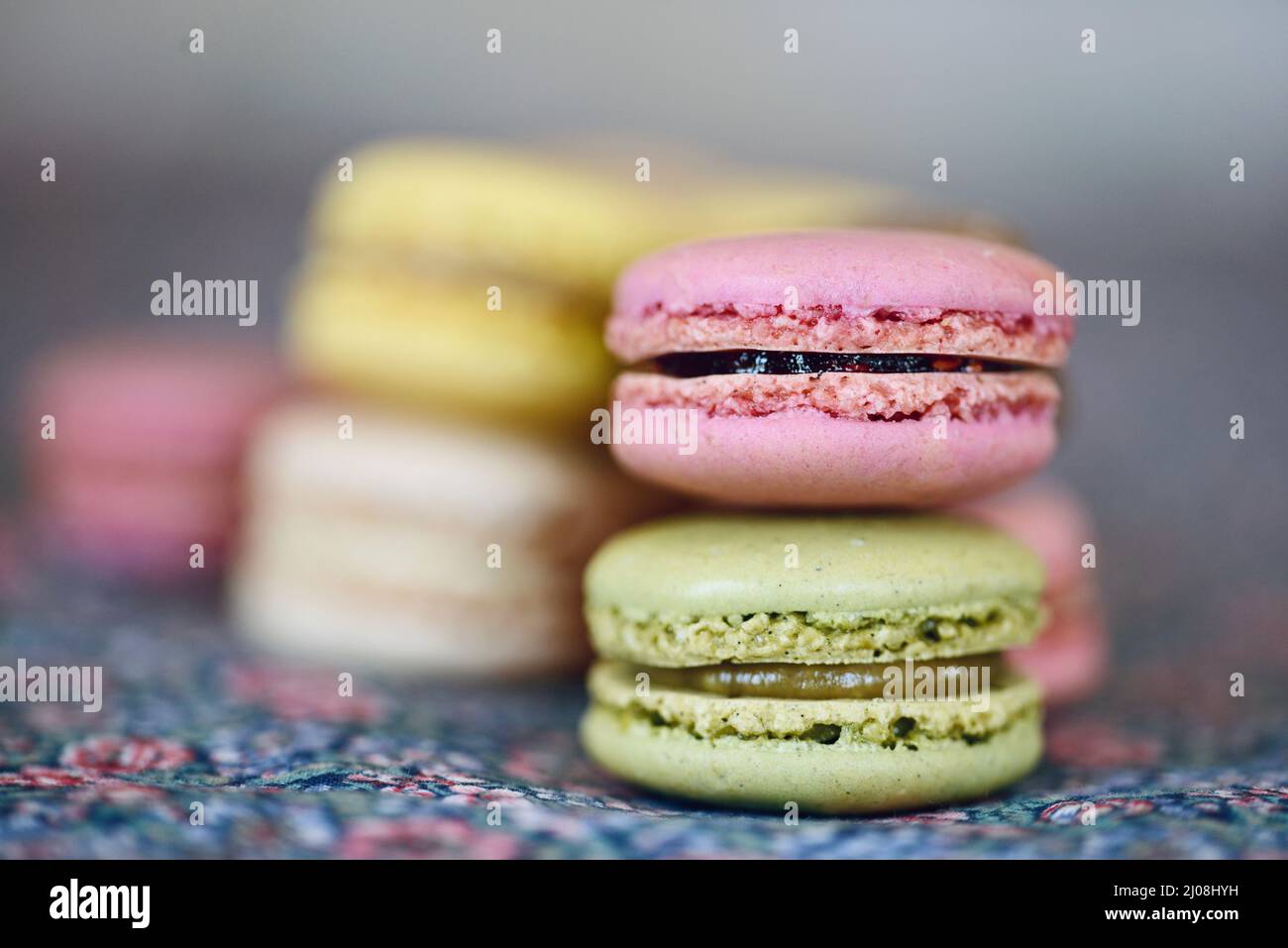 Pila di graziosi biscotti al macaron francese color pastello con luce naturale Foto Stock