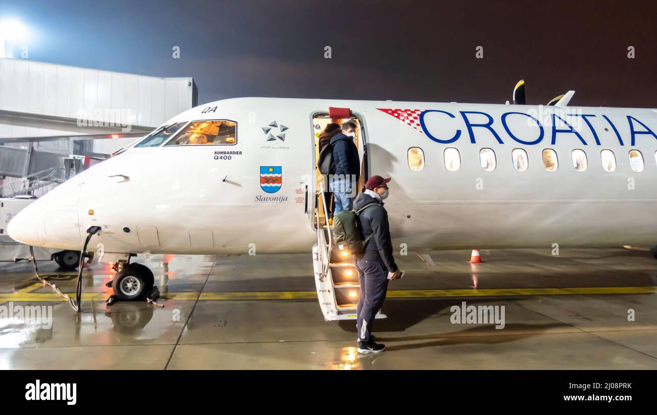 Passeggeri a bordo di Bombardier Q400 turboprop operata da compagnie aeree della Croazia nella notte, aeroporto di Zagabria, Croazia Foto Stock