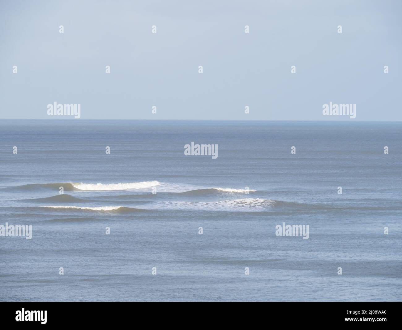 Mare calmo, piccole onde che si infrangono, sfondo bellissimo. Foto Stock