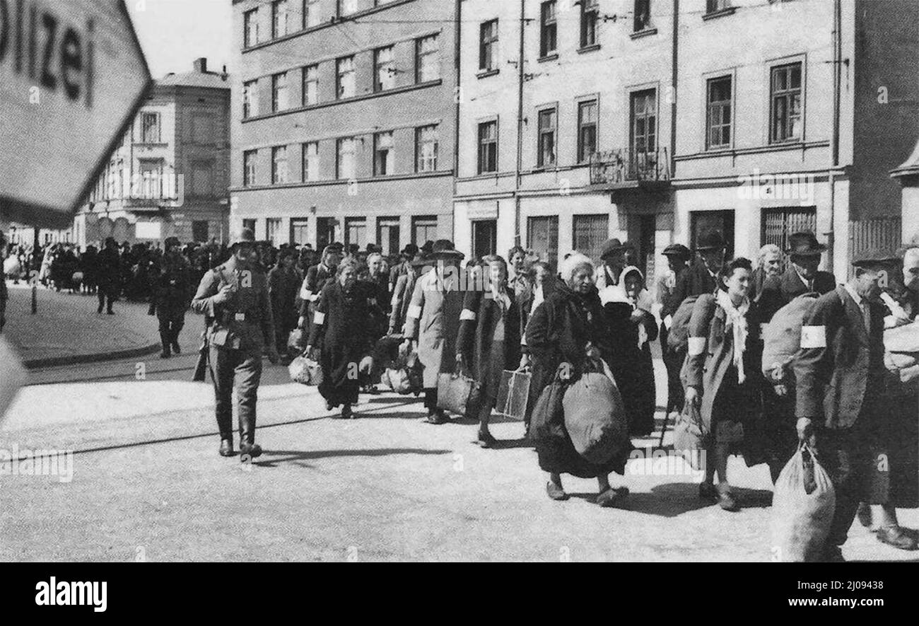 La Germania occupò la Polonia. Una colonna di ebrei prigionieri marcia con fasci lungo la via principale di Cracovia durante la liquidazione del Ghetto di Cracovia. Le guardie SS sorvegliano l'azione di deportazione nei campi di sterminio. Foto Stock