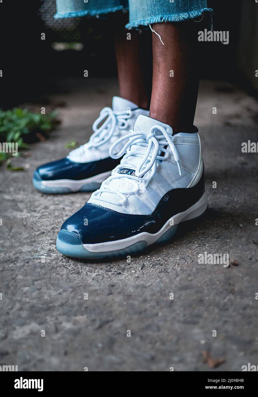 Messa a fuoco superficiale di piedini in pelle scura con scarpe Air Jordan  XI (11) bianche e blu Foto stock - Alamy