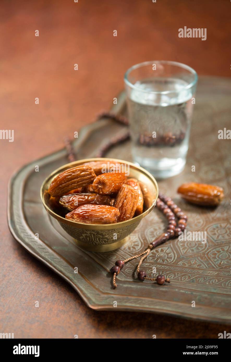 Datteri con acqua potabile - rompere velocemente iftar durante il mese santo del Ramadan. Le datteri sono frutti sacri che si consumano durante il mese santo del Ramadan. Foto Stock