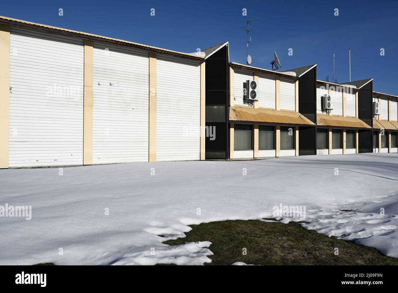 abbandonato edificio non residenziale con parabola satellitare sul tetto in inverno, deadpan fotografia Foto Stock