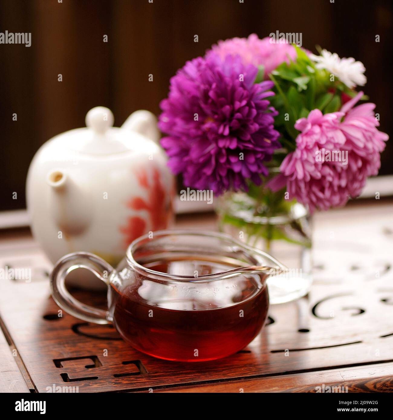 Bouquet di cerotti viola e rosa e tè nero su scolpito vassoio di tè piazza Foto Stock
