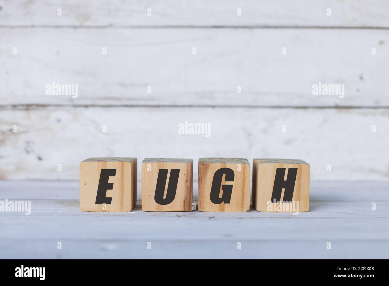 Concetto Eugh scritto su cubi o blocchi di legno, su sfondo bianco di legno. Foto Stock