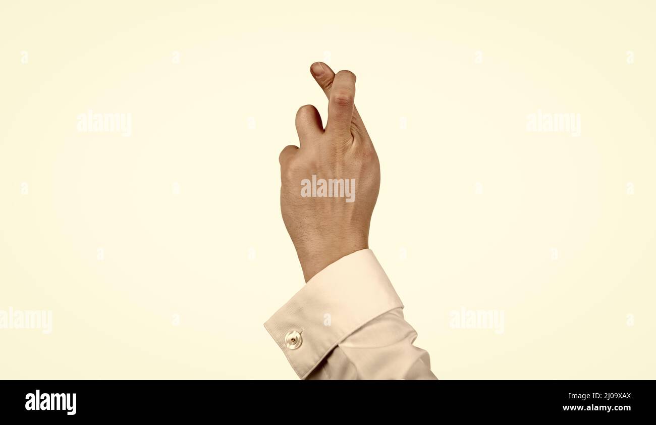 dita incrociate gesto di fare un desiderio con mano maschile isolato su bianco, false promesse Foto Stock