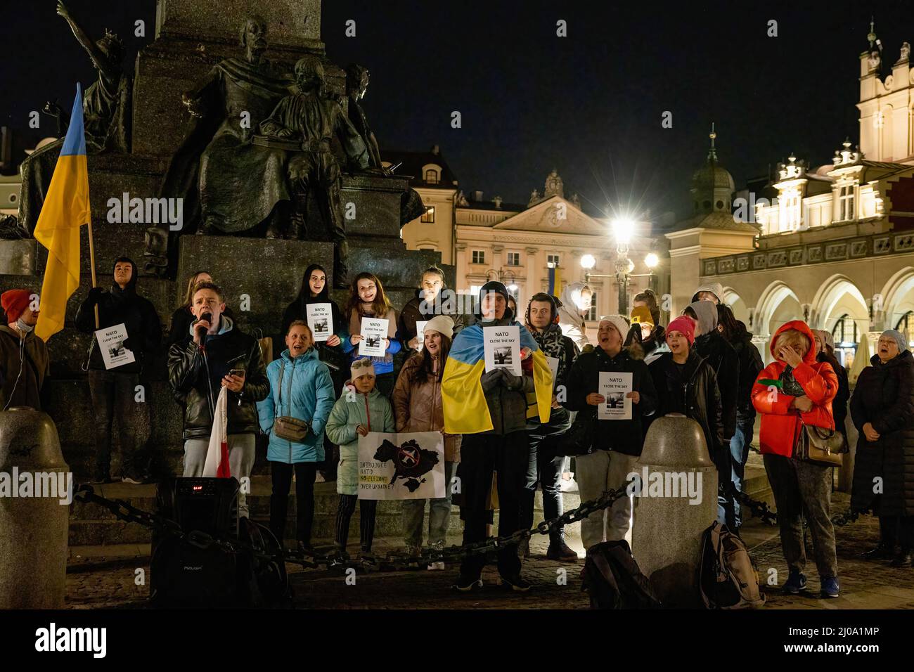 Cracovia, Polonia. 17th Mar 2022. Durante la manifestazione si vedono manifestanti che tengono cartelli e cantano l'inno nazionale ucraino. I manifestanti si sono riuniti nella piazza principale del mercato nella città vecchia di Cracovia per chiedere alla NATO di chiudere lo spazio aereo sopra l'Ucraina per proteggere il paese dai bombardamenti russi. Credit: SOPA Images Limited/Alamy Live News Foto Stock