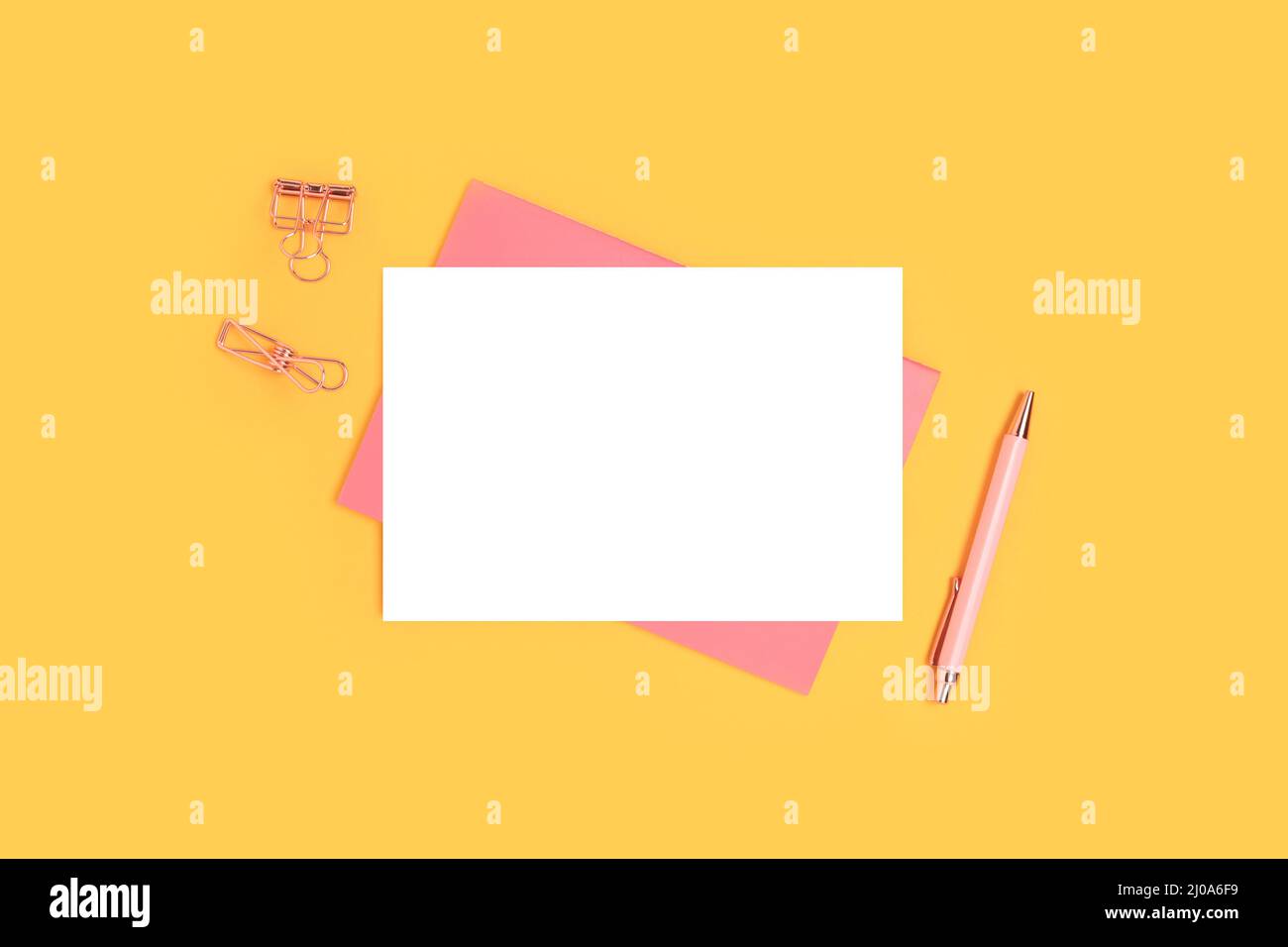 Mockup di carte di carta e cancelleria rosa su sfondo giallo. Spazio di lavoro minimalistico. Foto Stock