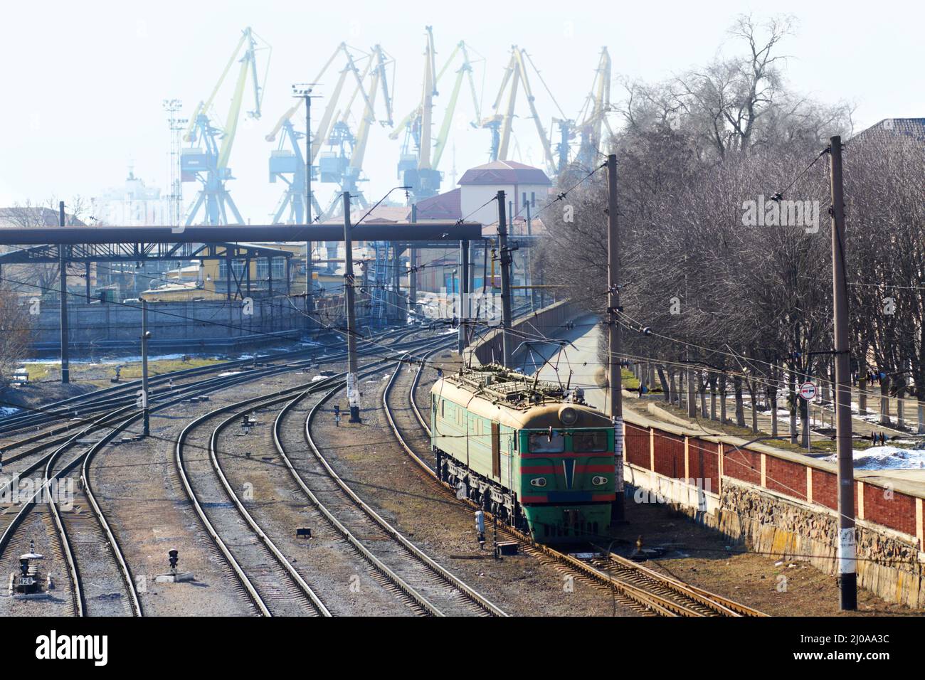 Industria urbana e viaggi. Girato di un treno in pista con l'industria in background. Foto Stock