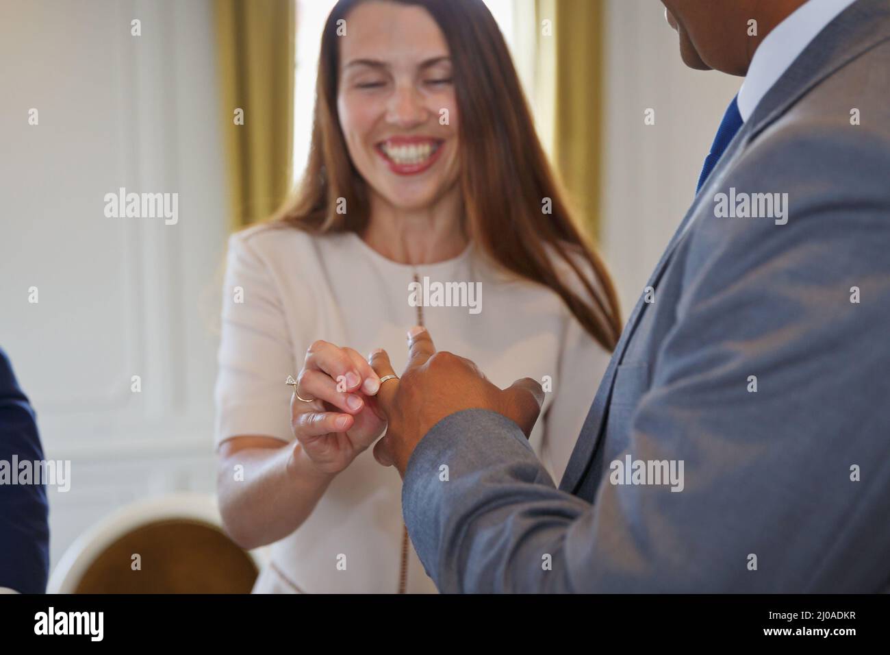 Coppia interrazziale bianca e nera mista di razza che tiene le mani e scambiano voti e anelli di nozze alla cerimonia di nozze. Famiglia multirazziale Foto Stock