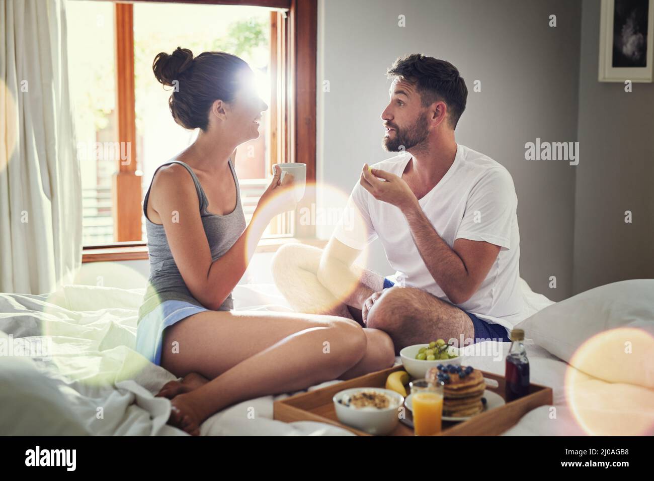 Non avete idea di quanto sono felice in questo momento. Scatto di una giovane coppia felice che si gode la colazione a letto insieme a casa. Foto Stock