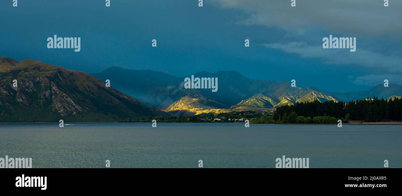 I raggi del sole brillano sulle colline dal lago Wanaka, regione di Otago, Nuova Zelanda. Foto Stock