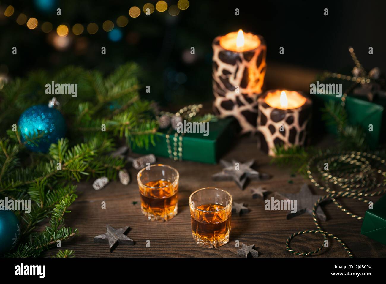 Due bicchieri di whiskey o bourbon con decorazione Holiday su sfondo di legno. Capodanno, Natale e le vacanze invernali whiskey mood concept Foto Stock