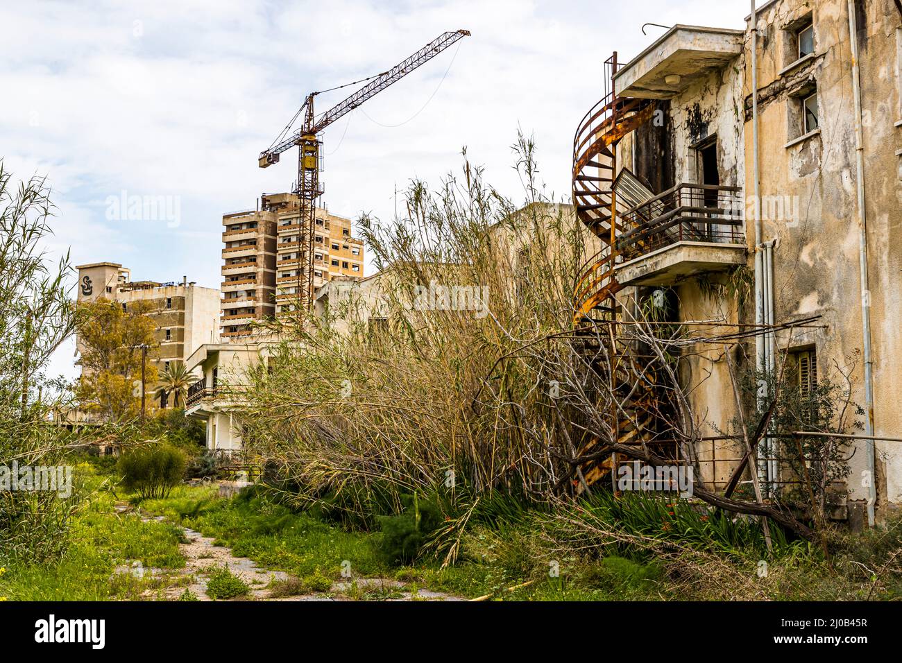 Molti edifici a Varosha erano ancora in costruzione nel 1974. Il distretto di Varosha (Kapalı Maraş) a Famagosta (Cipro) era tra il 1970 e il 1974 una delle destinazioni turistiche più popolari del mondo. I suoi abitanti grecociprioti fuggirono durante l'invasione turca di Cipro nel 1974, quando la città di Famagosta venne sotto il controllo turco. Da allora è rimasta abbandonata e gli edifici sono decaditi. Foto Stock