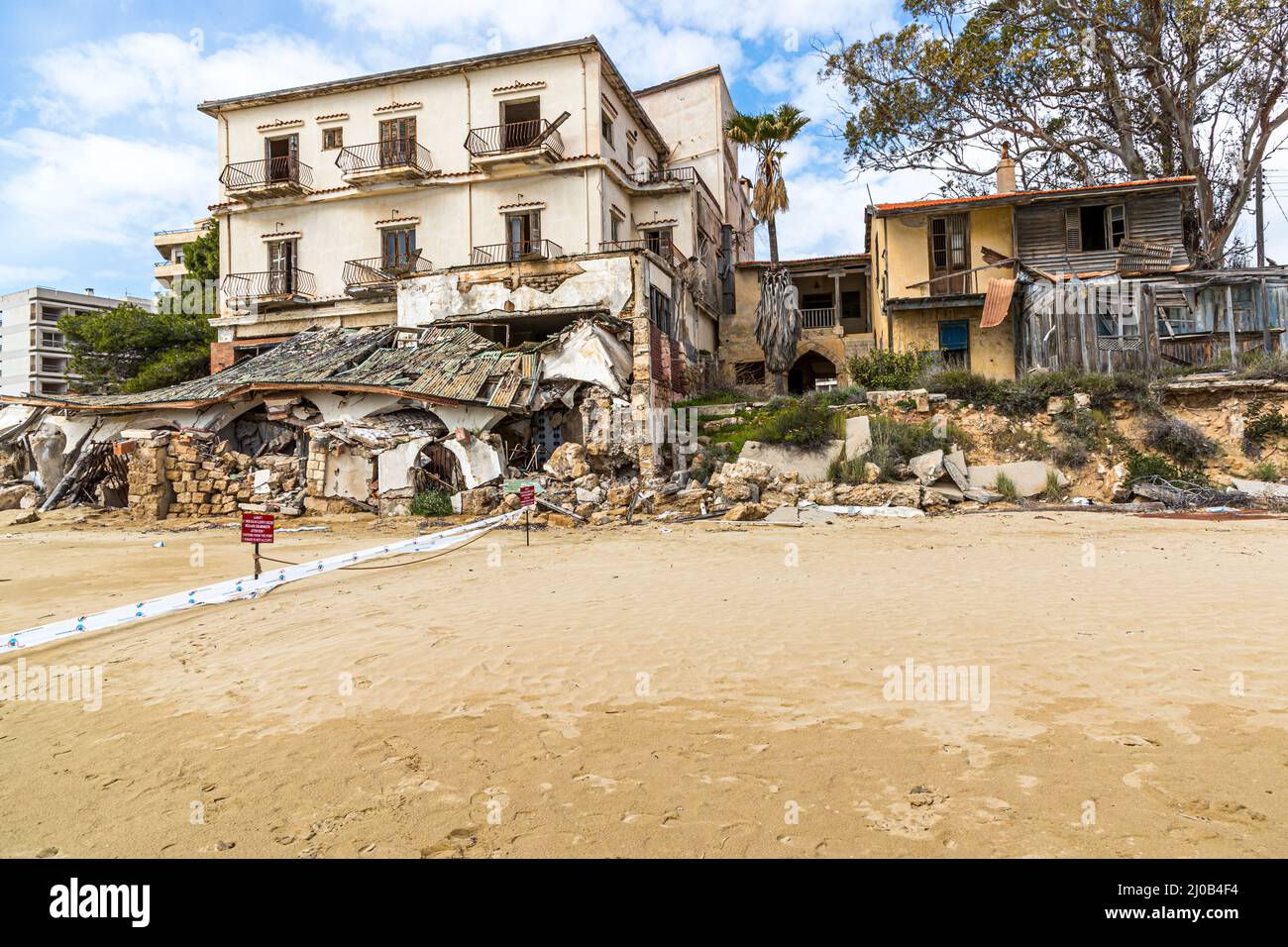 La facciata del King George Hotel sulla spiaggia di sabbia lunga 8 km di Varosha. Il distretto di Varosha (Kapalı Maraş) a Famagosta (Cipro) fu tra il 1970 e il 1974 una delle destinazioni turistiche più popolari al mondo. I suoi abitanti greco-ciprioti fuggirono durante l'invasione turca di Cipro nel 1974, quando la città di Famagosta passò sotto il controllo turco. Da allora è rimasto abbandonato e gli edifici sono decaduti. La maggior parte degli abitanti originari di Varosha (e dei loro diretti discendenti) vive ora a sud della zona cuscinetto delle Nazioni Unite di Cipro. Quelle famiglie sono ancora i legittimi proprietari di proprietà in V Foto Stock