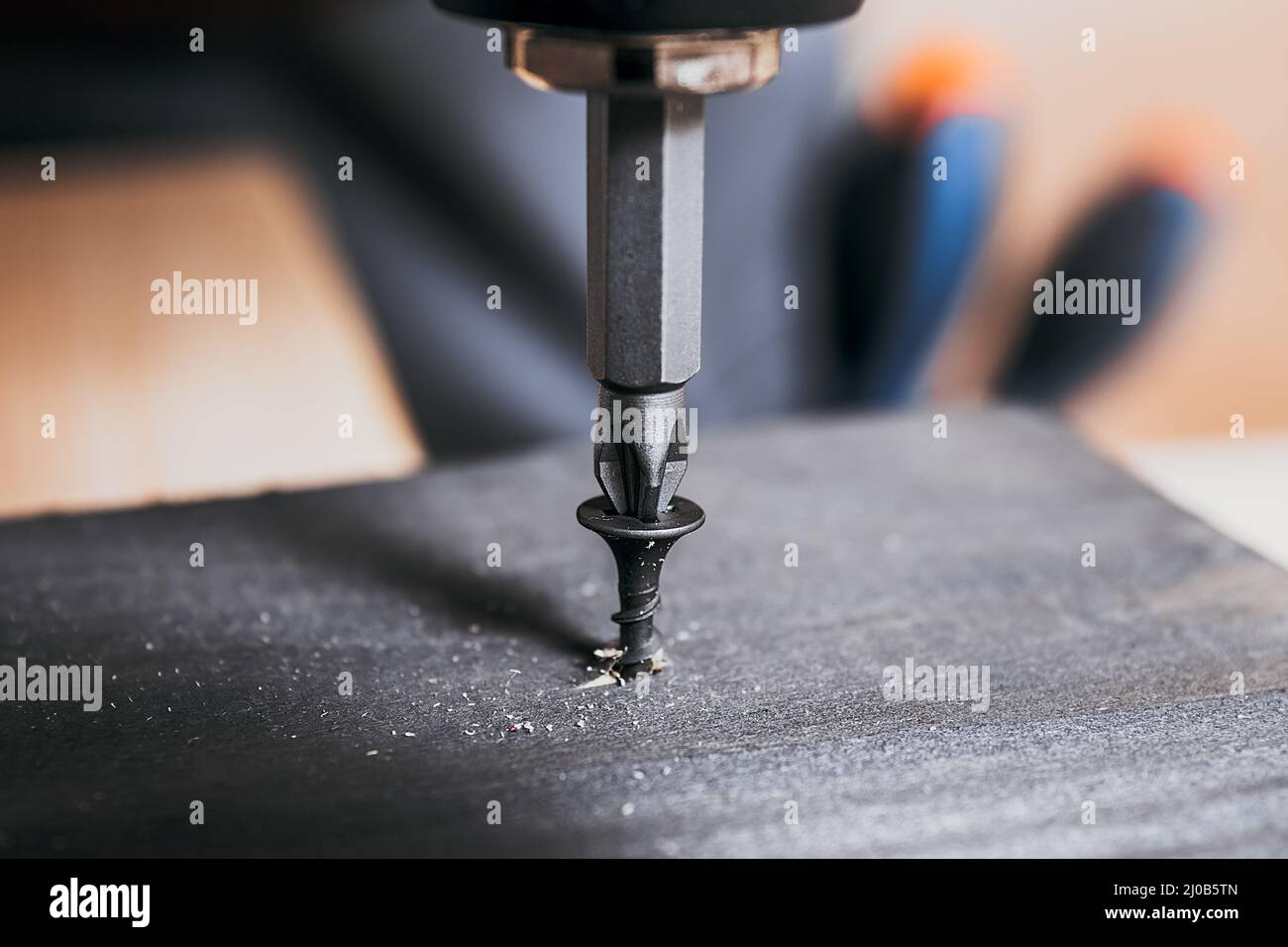 Avvitare in legno sul fondo del piano in legno. Cacciavite elettrico o forare la vite, il chiodo o il bullone di avvitamento in tavole di legno. Riparare Foto Stock