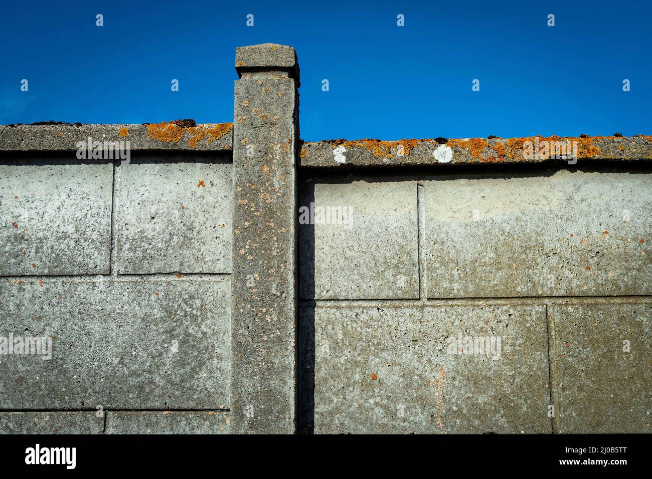 Struttura a parete sotto un cielo azzurro trasparente che mostra materiali in cemento e design a mezzogiorno Foto Stock