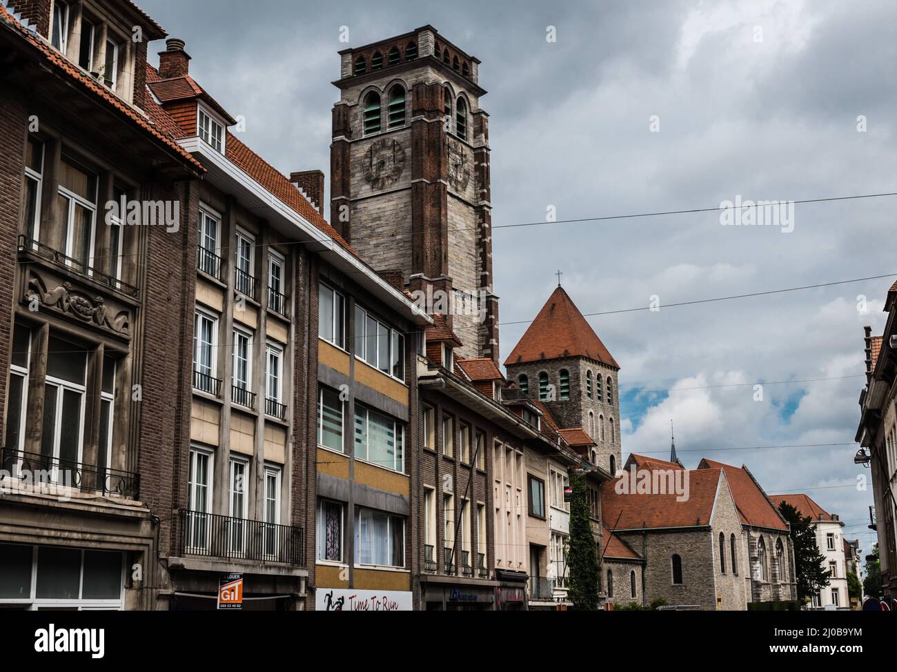 Tournai Doornik, Regione Vallone - Belgio - 08 14 2019 facciate di edifici residenziali e commerciali nella città vecchia con la torre del San Brice c Foto Stock