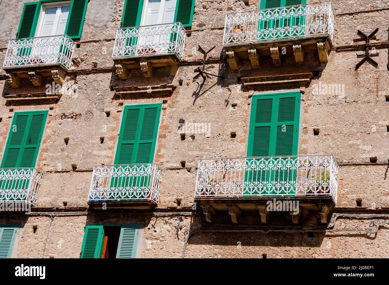 Italiano casa di pietra davanti con otturatore verde persiane e balcone a Tropea Foto Stock