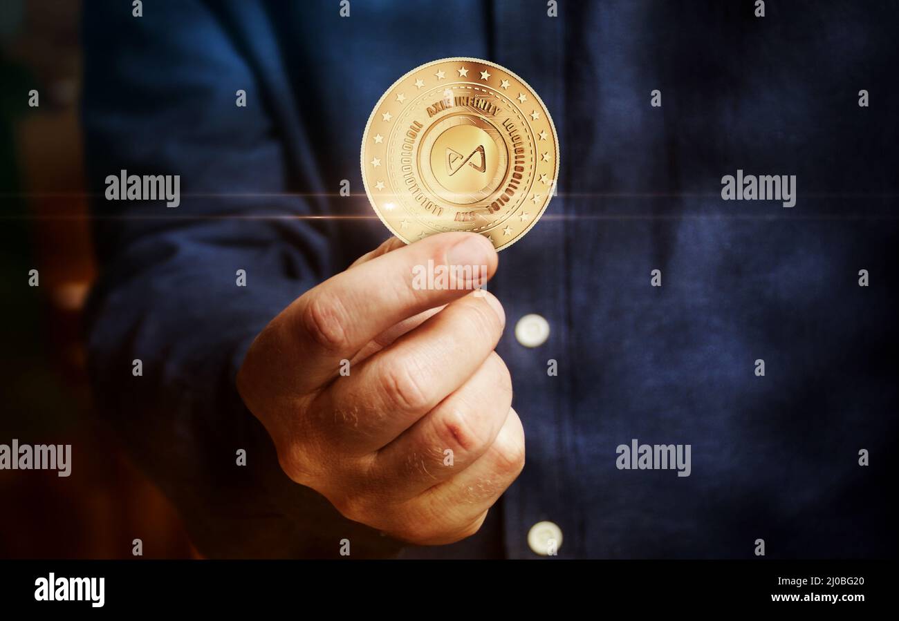 Axie AXS Infinity, simbolo di criptovaluta del gioco moneta d'oro in mano concetto astratto.» Foto Stock