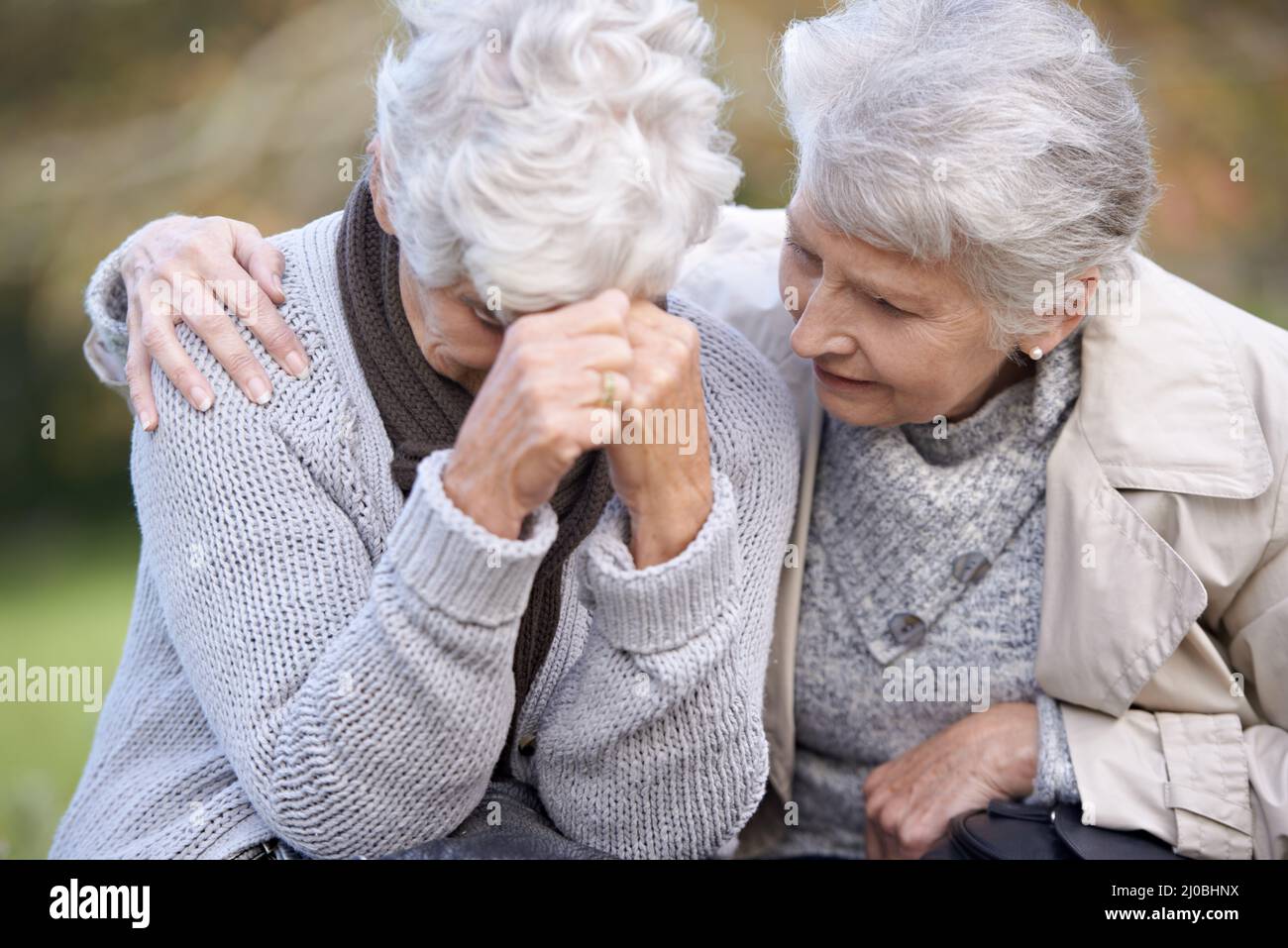 Siamo sempre lì l'uno per l'altro. Una donna anziana consolante la sua amica mentre si siedono all'aperto. Foto Stock