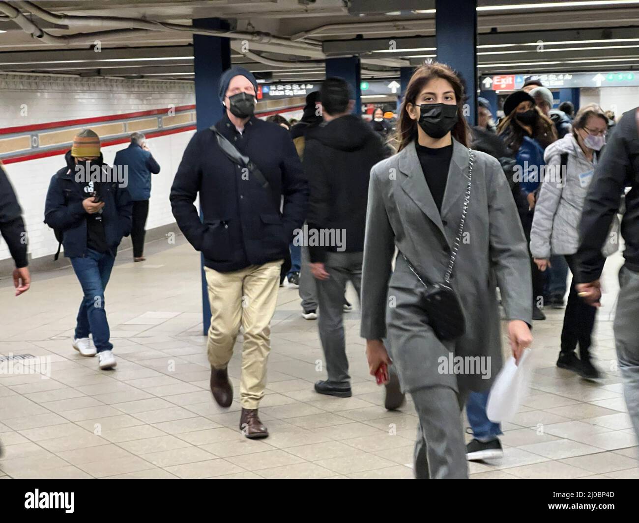 I motociclisti scurry attraverso i corridoi tra i treni e le uscite della metropolitana alla grande Union Square Subway Station al 14th Street a New York City. Foto Stock