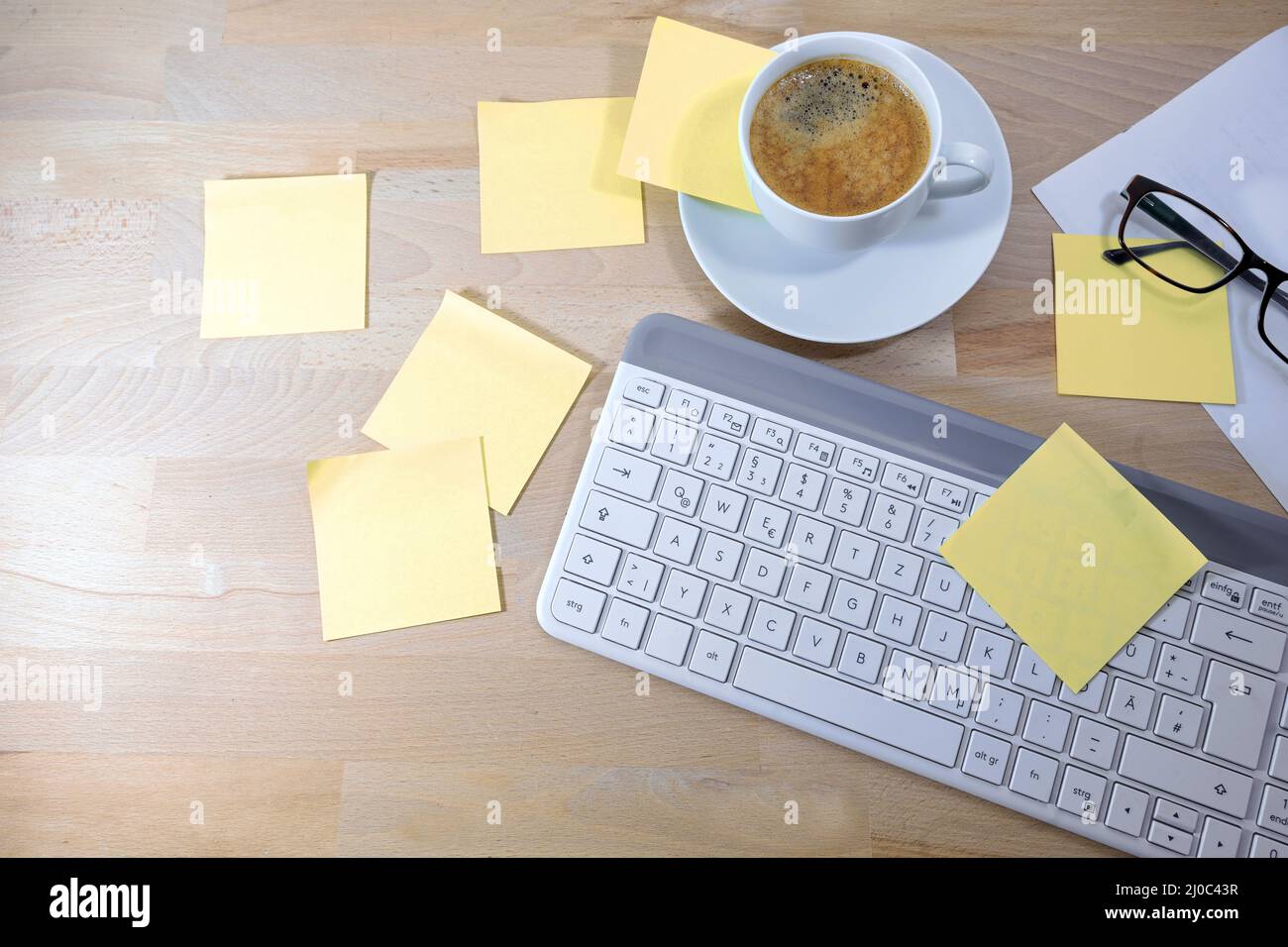 Scrivania da ufficio con un sacco di note adesive vuote o post it Notes, tastiera per computer e tazza di caffè, business a casa, concetto per l'organizzazione e ricordare Foto Stock