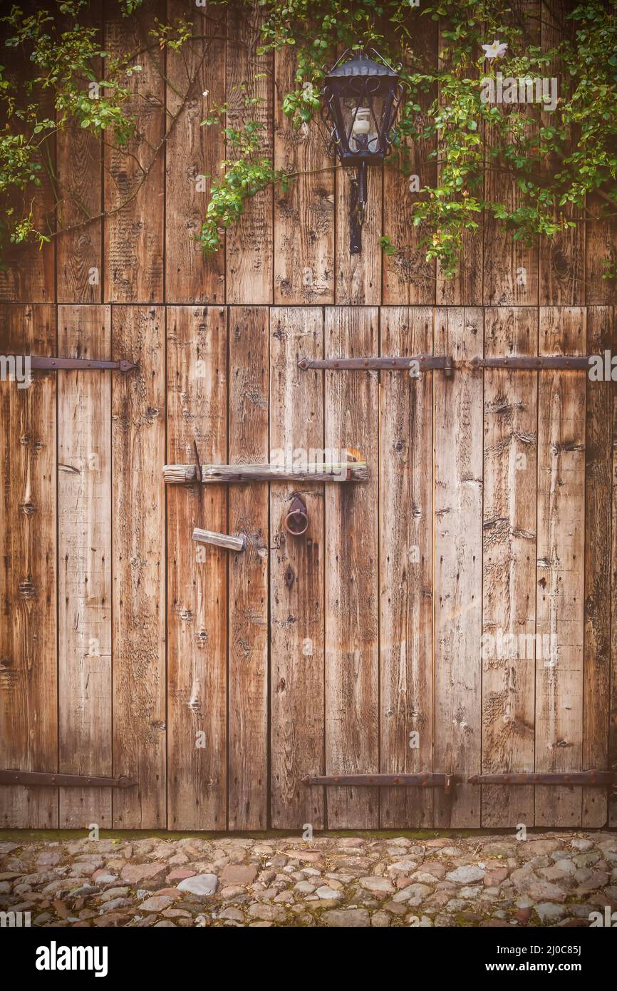Weathered vecchio fienile in legno porta con cerniere in acciaio Foto Stock