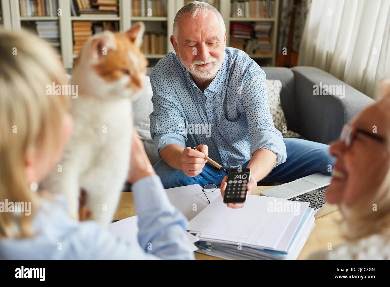 Contabile con calcolatrice che fornisce consulenza agli anziani in merito al piano pensionistico e alla pensione Foto Stock