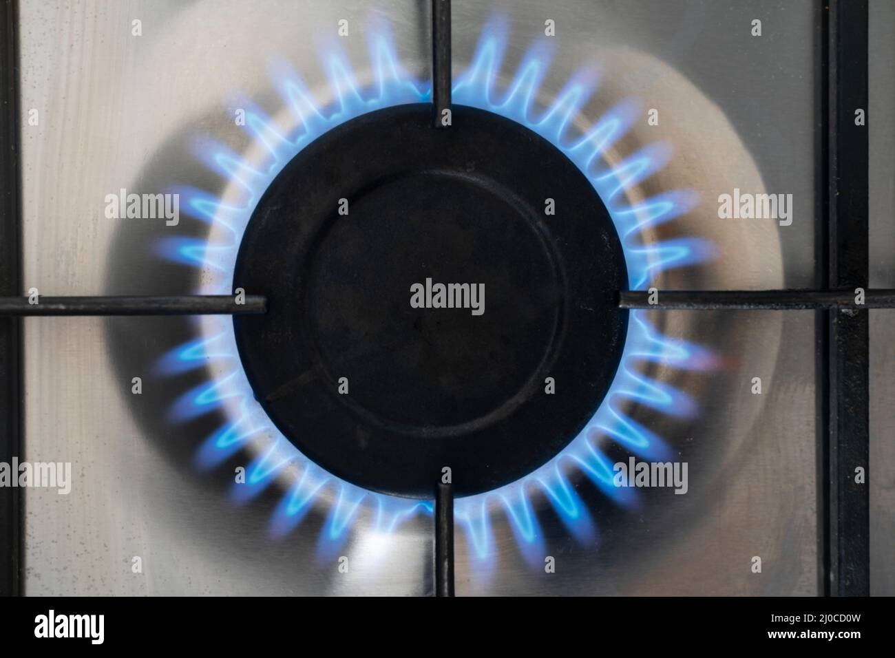 Una fiamma blu su un fornello a gas naturale in Inghilterra. Tema: Tetto dei prezzi dell'energia, bollette energetiche in aumento, fornitura di gas, forniture di gas, gas russo, gonfiaggio elevato Foto Stock